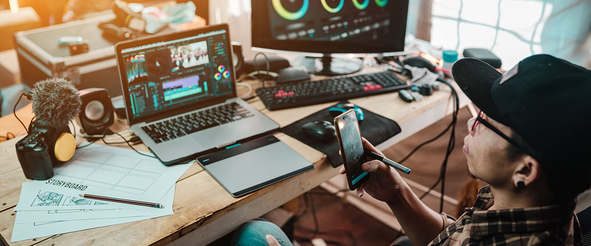 Man working with editing equipment at desk on film or TV production